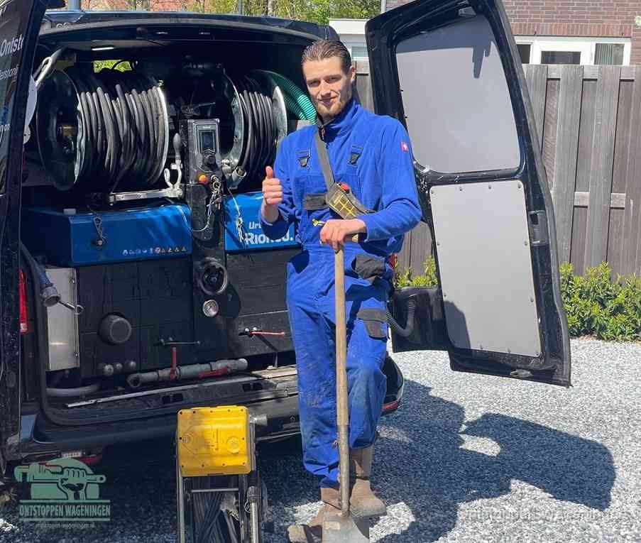 Een tevreden monteur met opgestoken duim naast de bestelbus, slim ingrijpen bespaart kosten bij een verstopte afvoer in Wageningen