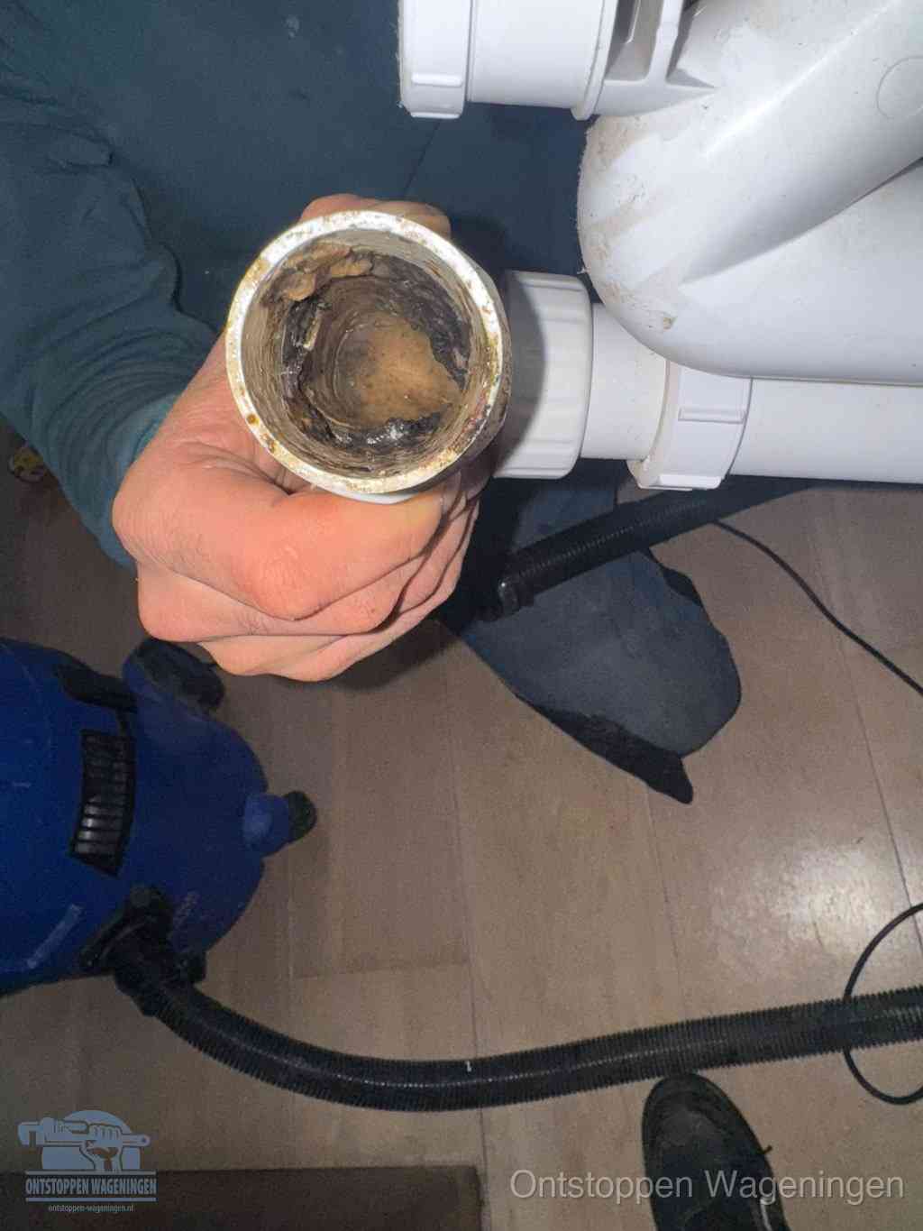 Een losgekoppeld afvoerbuisstuk dat van binnen volledig is dichtgeslibd, het gevolg van een verstopping te lang laten zitten in Wageningen