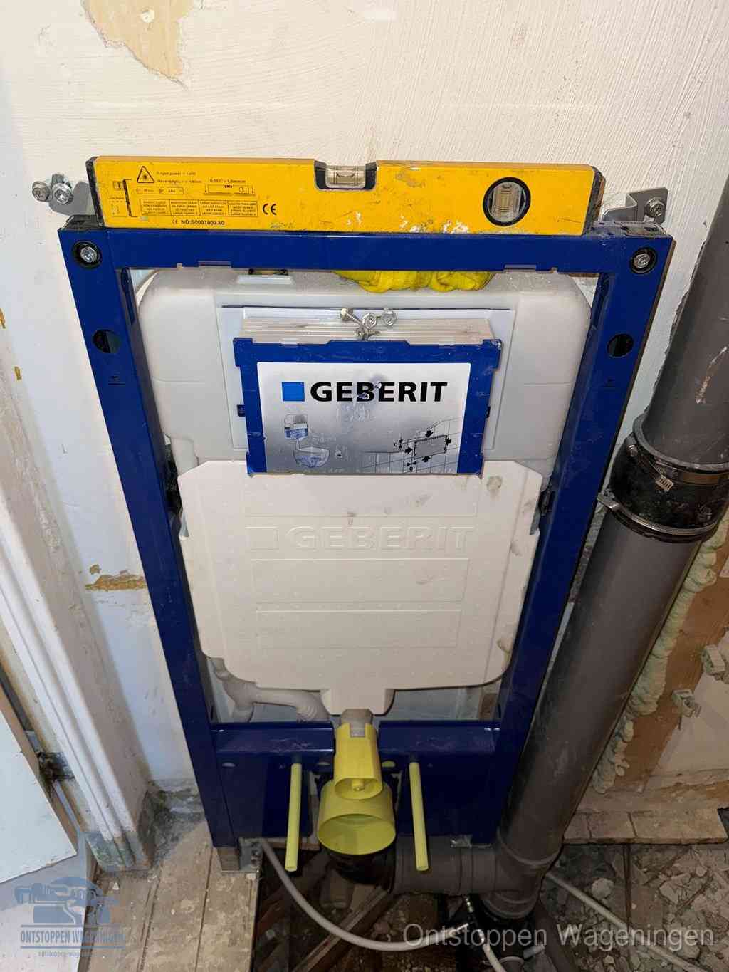 Een Geberit inbouwreservoir met frame voor een hangtoilet tegen de wand, met de afvoerbocht naar de vloer, kenmerkend voor een verstopt hangtoilet in Wageningen