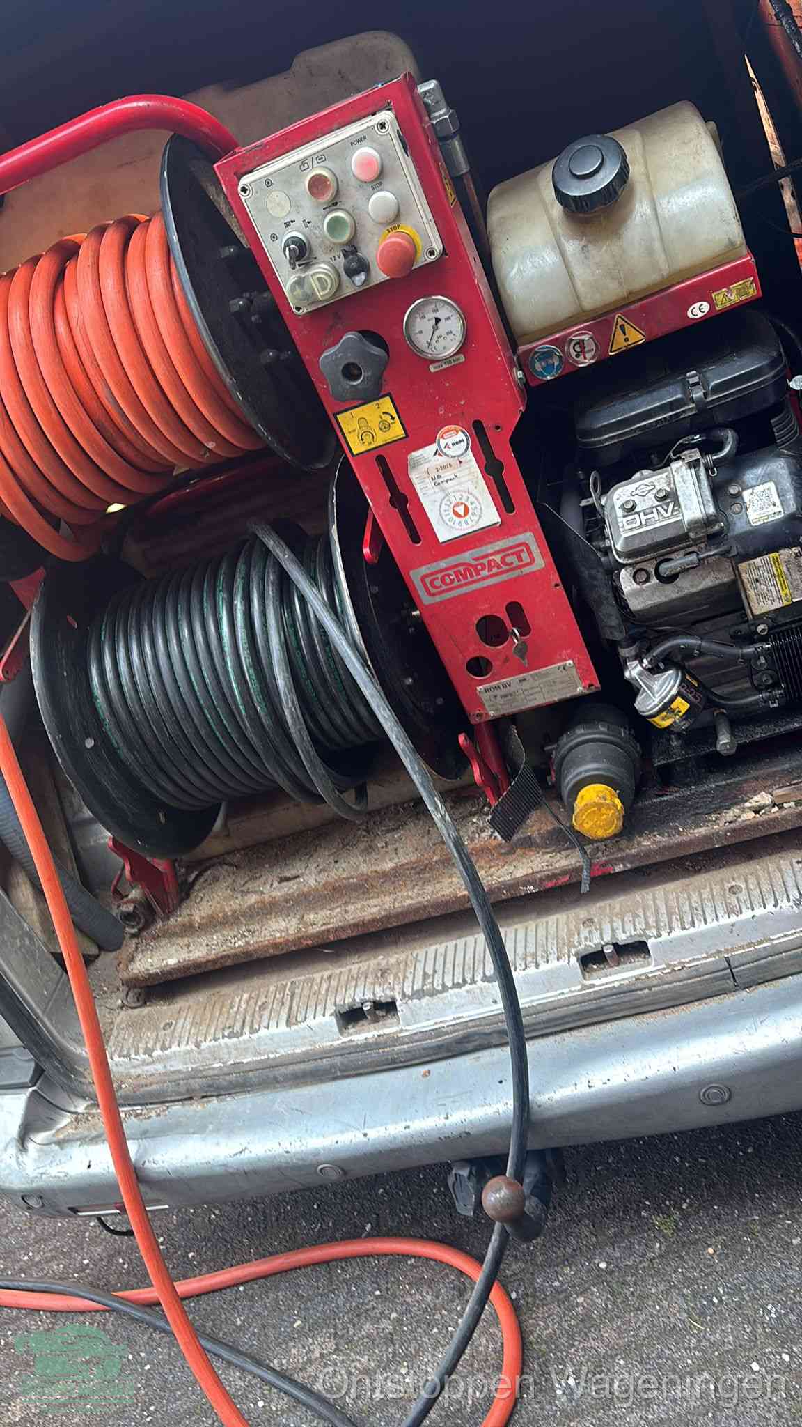 Een rood hogedruk-rioolreinigingstoestel in de laadbak van de bedrijfsbus, apparatuur voor een hardnekkige afvoerverstopping in Wageningen