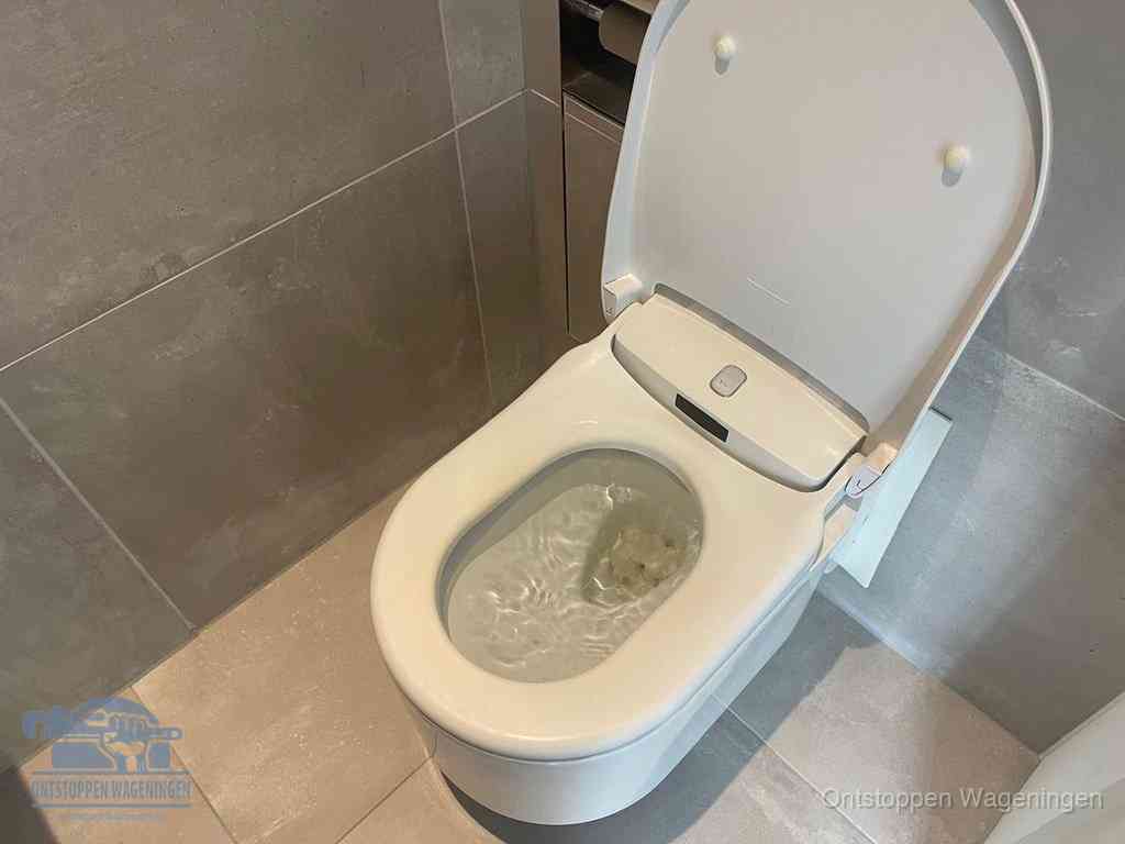 Een toiletpot vol troebel water met drijvend papier en restanten, de meest voorkomende oorzaak van een verstopte wc in Wageningen