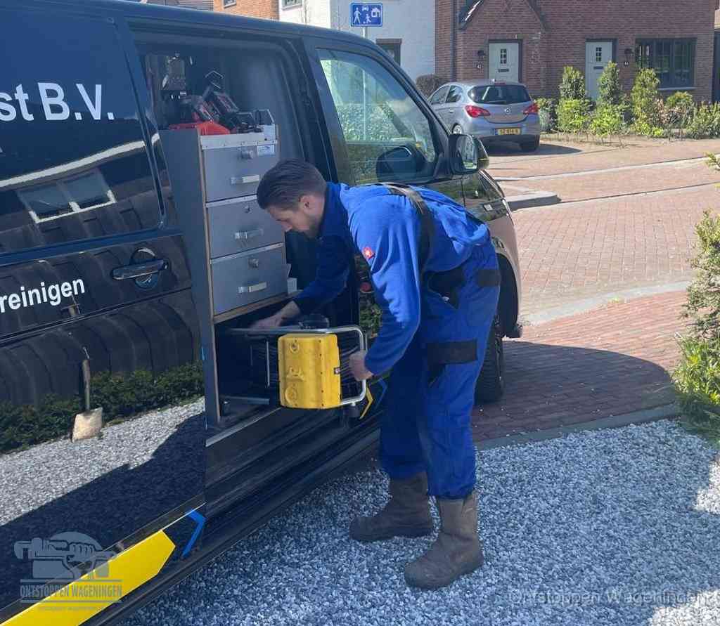 Een monteur pakt apparatuur uit de bedrijfsbus voor service aan huis, het moment om een professional in te schakelen in Wageningen